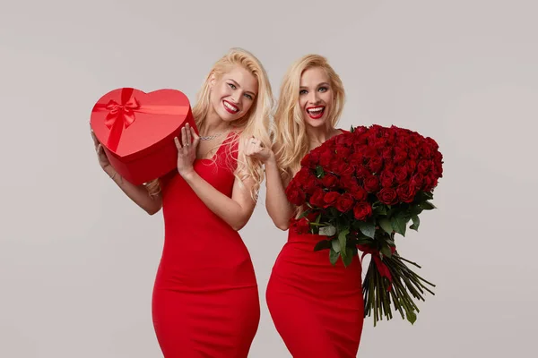 Twee Vrolijke Tweelingvrouwen Met Een Groot Boeket Rode Rozen Een — Stockfoto