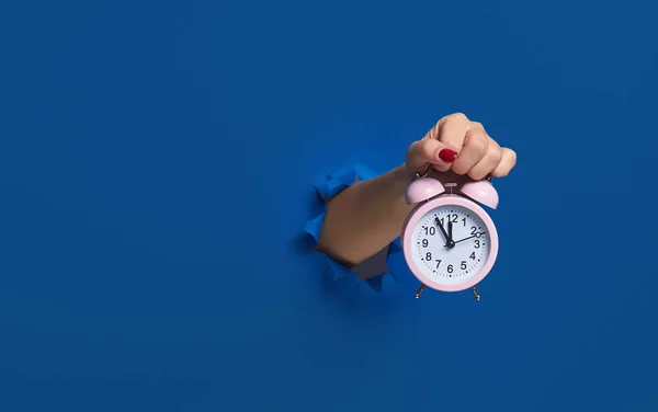 Uyan! Uyan! Pembe çalar saat, yırtık mavi kağıt bir duvarın içinden geçiyor, maket. Mesaj için yer var. Zamanımız azalıyor. Son teslim tarihi. Zaman yönetimi ve disiplin kavramı