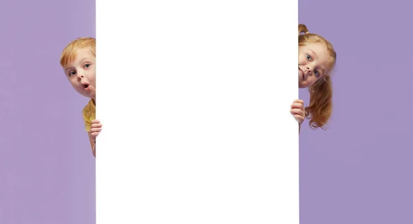 Two Little Children Holding White Banner Purple Background Funny Faces — 스톡 사진