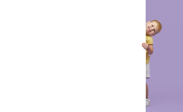 Kleines Lächelndes Kind Das Hinter Einer Weißen Platte Vor Violettem — Stockfoto
