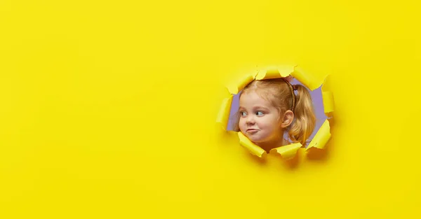 Een Klein Verrassend Kind Kijkend Door Het Felgele Papiergat Adverteren — Stockfoto