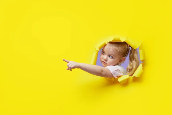 Criança Pouco Surpreso Olhando Espiando Através Buraco Papel Amarelo Brilhante — Fotografia de Stock