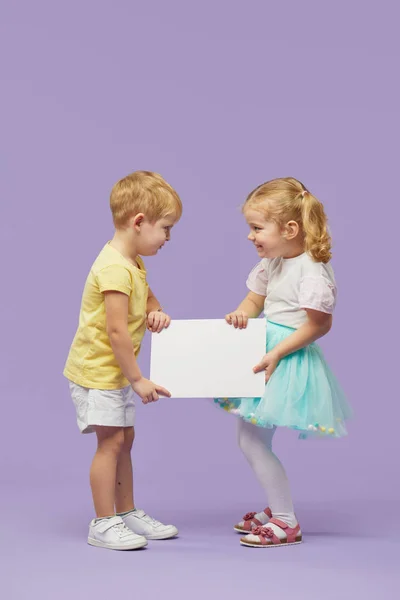 Twee Kleine Kinderen Met Een Wit Spandoek Een Paarse Achtergrond — Stockfoto