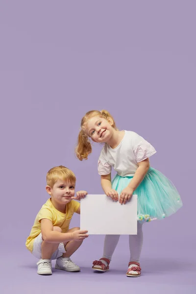 Twee Kleine Kinderen Met Een Wit Spandoek Een Paarse Achtergrond — Stockfoto