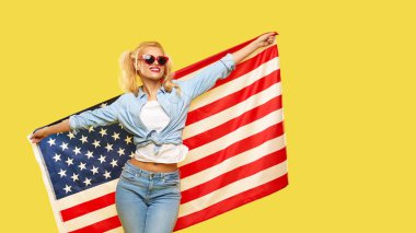 American girl. Happy young woman in denim clothes holding USA flag isolated on yellow background