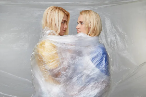 Two Young Upset Women Wrapped Indestructible Polyethylene Problem Environmental Pollution — 스톡 사진