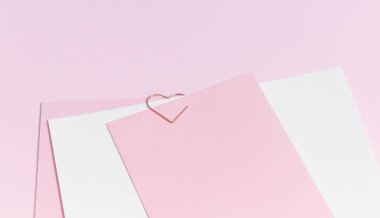 Empty template for romantic letters on a pink background. White feather with gold plating. Real photo, flat lay. Copy space for text.