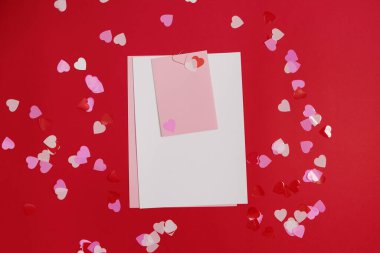 Kırmızı arkaplanda romantik harfler için boş bir şablon. Kalp şeklinde kırmızı kalem. Gerçek fotoğraf, düz yatış. Metin için alanı kopyala.