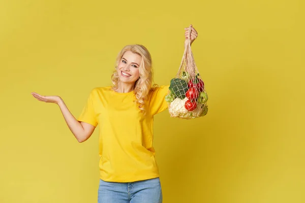 Giovane Donna Tenere Una Borsa Stringa Piena Verdure Biologiche Sfondo — Foto Stock