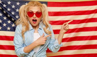 American girl. Portrait of Happy of young surprised woman on USA flag  background. Funny human face. Patriotism concept