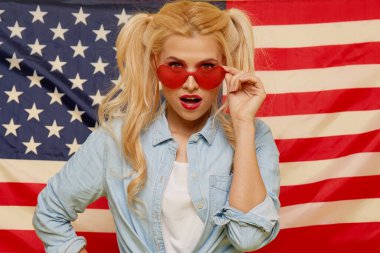 American girl. Portrait of Happy of young surprised woman on USA flag  background. Funny human face. Patriotism concept