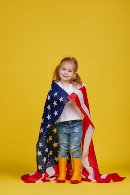 Vatansever bayram. Mutlu çocuk, sarı stüdyo geçmişinde Amerikan bayrağı olan sevimli küçük kız. Usa 4 Temmuz 'u kutluyor, Bağımsızlık Günü.