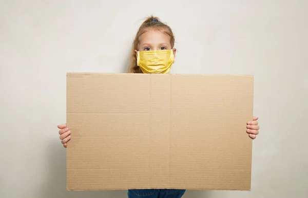 保護医療マスクの少女の子供は テキストのための大きな空白のバナーを保持しています 流行の世界隔離概念 — ストック写真