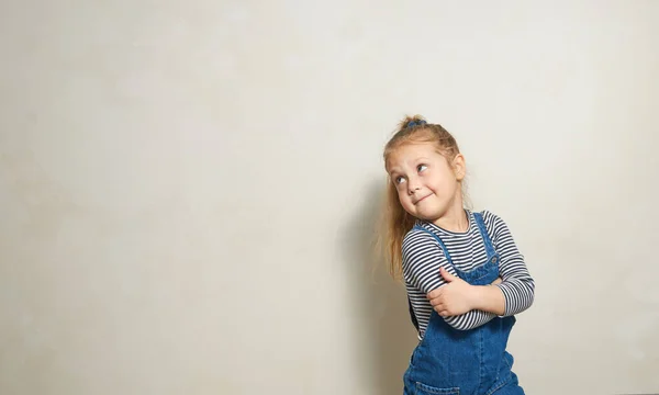 Niño Divertido Niña Para Cerca Una Pared Blanca Con Interés — Foto de Stock