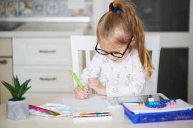 Çevrimiçi Eğitim kavramı. Küçük kız bilgisayarını evde öğrenim görmek için kullanıyor.