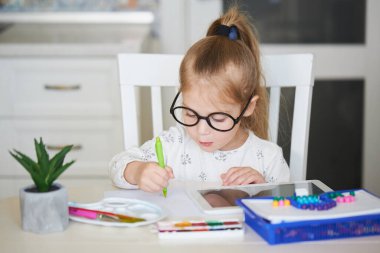 Çevrimiçi Eğitim kavramı. Küçük kız bilgisayarını evde öğrenim görmek için kullanıyor.