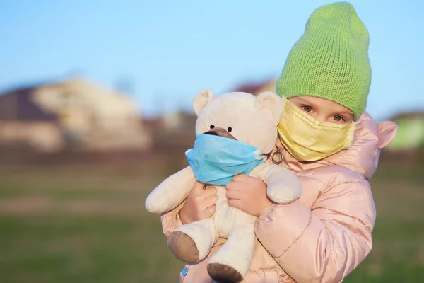 Gadis Kecil Bertopeng Pelindung Wajahnya Memegang Boneka Beruang Dalam Topeng — Stok Foto