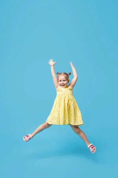 Πορτρέτο Του Χαμογελαστού Χαριτωμένο Κοριτσάκι Παιδί Πηδάει Απομονωμένο Μπλε Φόντο — Φωτογραφία Αρχείου