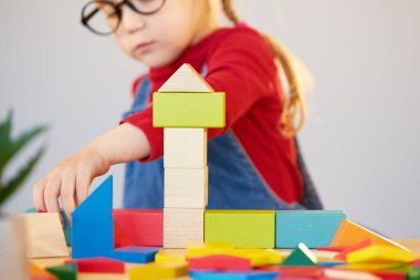 Karantina sırasında evde internet üzerinden öğrenme. Gözlüklü akıllı bir çocuk sınıftaki bir masada çok renkli bir müteahhit toplar..