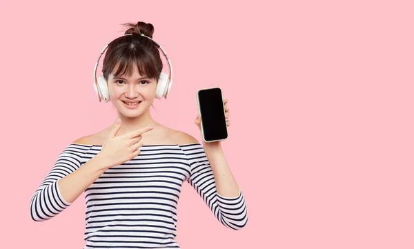 5G无限网络广告 用手机和无线耳机听音乐的年轻而快乐的亚洲女人的画像 — 图库照片