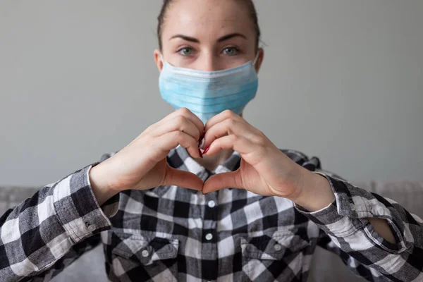 Onu virüsten korumak için tıbbi maskeli bir kız. Koronavirüs salgını. Maskeli kadın ayakta. İnsanlar Corona 'nın yayılmasını engellemek için hastaneye yatırılıyor, teşhis konuyor ve genellikle karantinaya alınıyor..