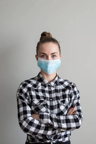 Onu virüsten korumak için tıbbi maskeli bir kız. Koronavirüs salgını. Maskeli kadın ayakta. İnsanlar Corona 'nın yayılmasını engellemek için hastaneye yatırılıyor, teşhis konuyor ve genellikle karantinaya alınıyor..