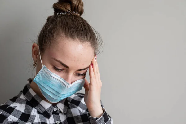 Onu virüsten korumak için tıbbi maskeli bir kız. Koronavirüs salgını. Maskeli kadın ayakta. İnsanlar Corona 'nın yayılmasını engellemek için hastaneye yatırılıyor, teşhis konuyor ve genellikle karantinaya alınıyor..