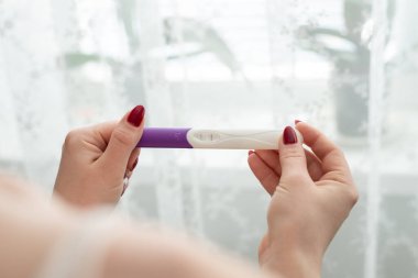 Bulanık arka planda kadın elinde hamilelik testi