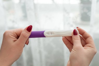 Bulanık arka planda kadın elinde hamilelik testi