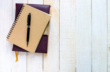 ahşap masa üstünde defter üzerinde üstten görünüm siyah kalem yer