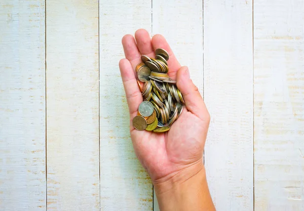 En üst görünüm, elde birçok madeni para, yatırım ve iş kavramları