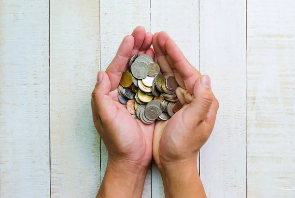 En üst görünüm, elde birçok madeni para, yatırım ve iş kavramları