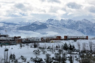 Şehir, dağlar ve bulutlar ile karlı manzara