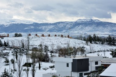Şehir, dağlar ve bulutlar ile karlı manzara