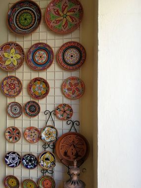bir duvarda asılı çok renkli seramik yemekleri
