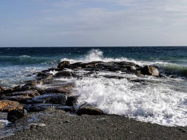 Bir sonbahar öğleden sonrasında dalgalar ve kayalarla dramatik bir deniz.