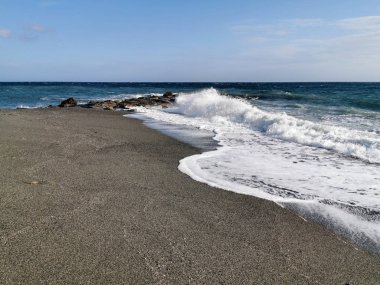 Bir sonbahar öğleden sonrasında dalgalar ve kayalarla dramatik bir deniz.