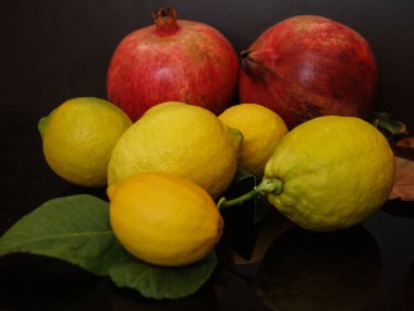 ripe lemons and pomegranates on table