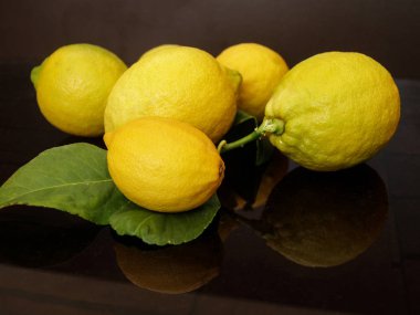 Koyu arkaplanda olgun sarı limonlar