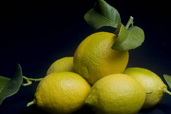 Olgun limonlar siyah arka planda, durgun hayat