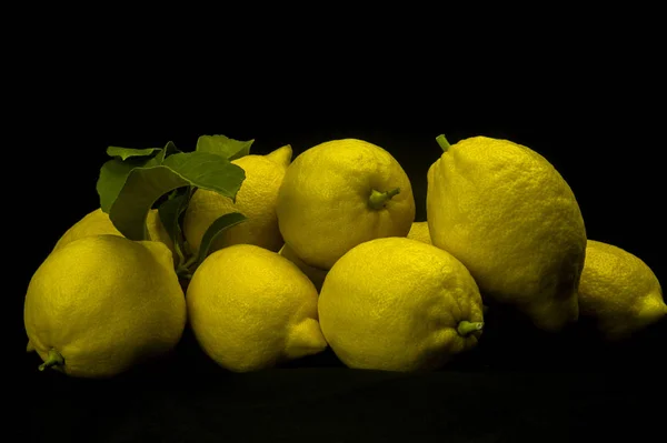 在黑色的背景上新鲜切出精美的柠檬 — 图库照片