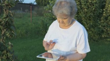 Açık havada tablet yaşlı kadın 80s tutarak bilgisayara