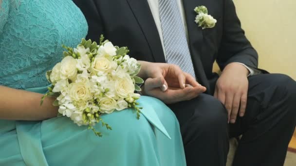 The bride and groom sitting on the biege sofa — Stock Video