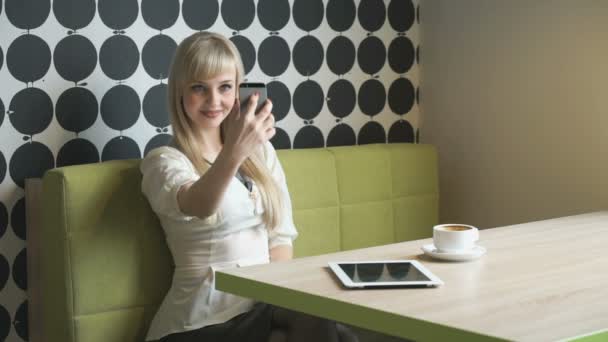 Menina loira faz selfie usando um telefone celular cinza — Vídeo de Stock