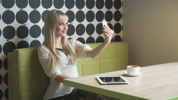 Blond tjej gör selfie med en grå mobiltelefon — Stockvideo