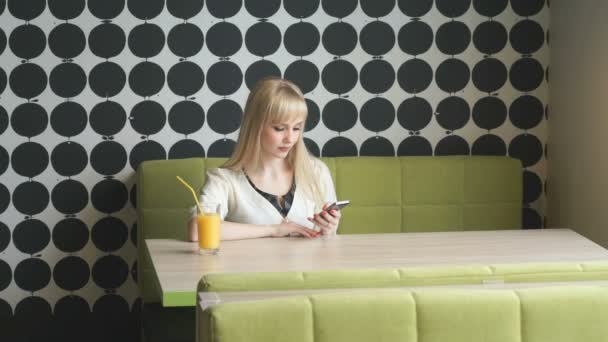 使用手机在咖啡馆里的女孩发短信短信 — 图库视频影像