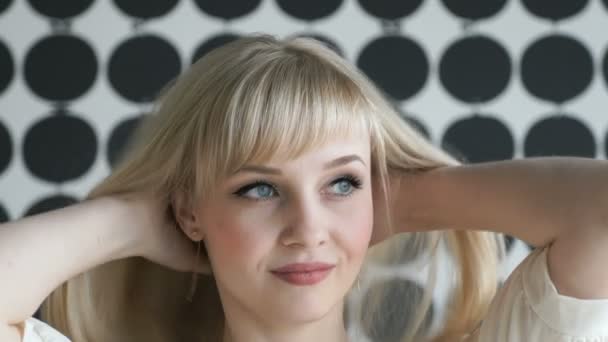 Blonde fille avec une épaisse chevelure souriant pour la caméra 