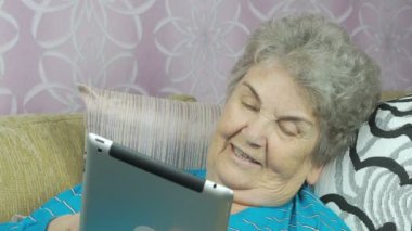 Gülümseyen kıdemli kadın üzerinde otel odası kanepe yatıyor