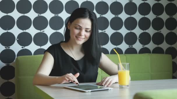 Chica bebe jugo de naranja en la cafetería — Vídeos de Stock