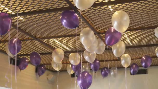 Bunte Luftballons schweben drinnen an der Decke — Stockvideo